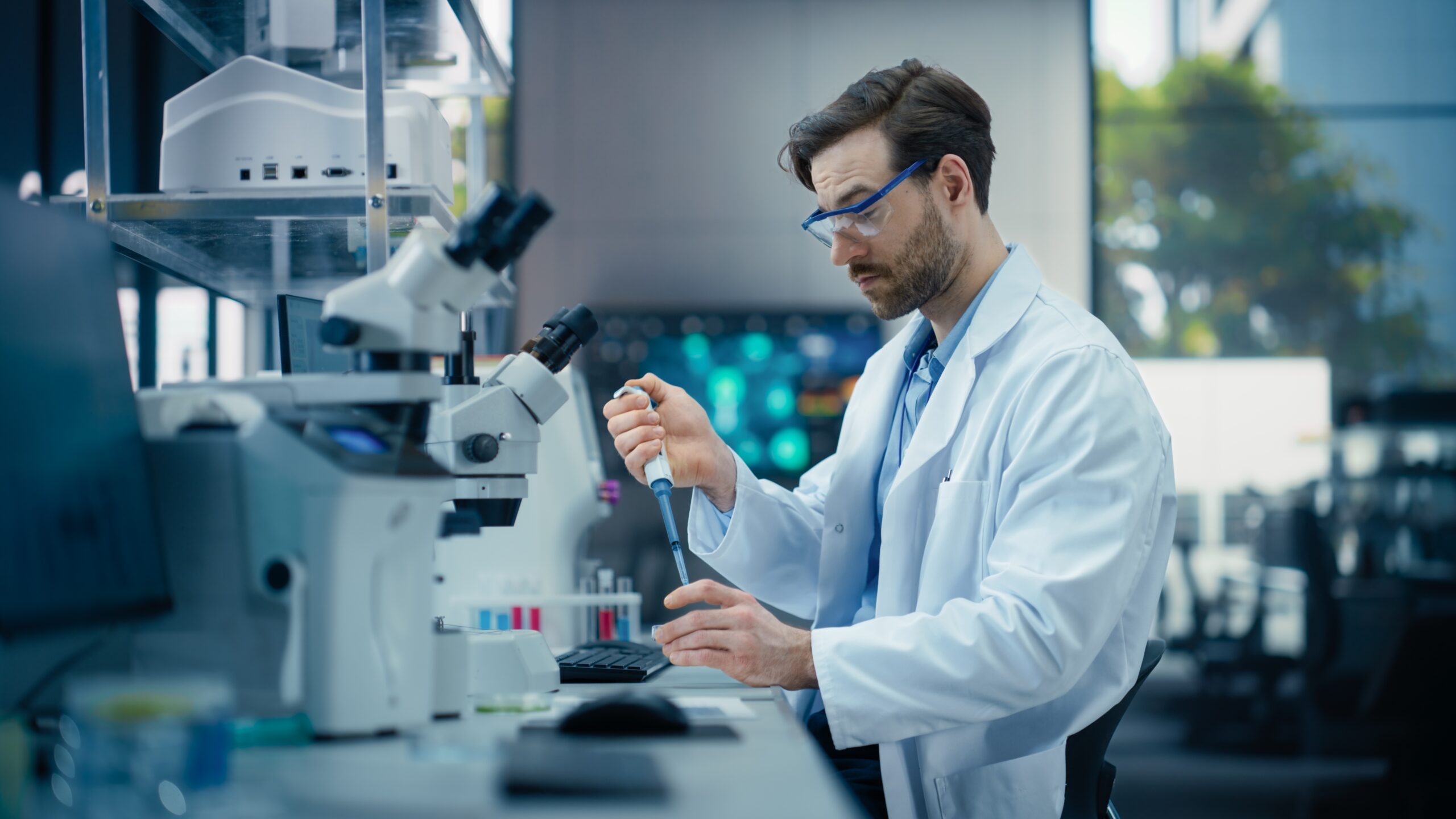 Ein Wissenschaftler steht in seinem Labor und experimentiert mit Reagenzgläsern und Mikroskopen.